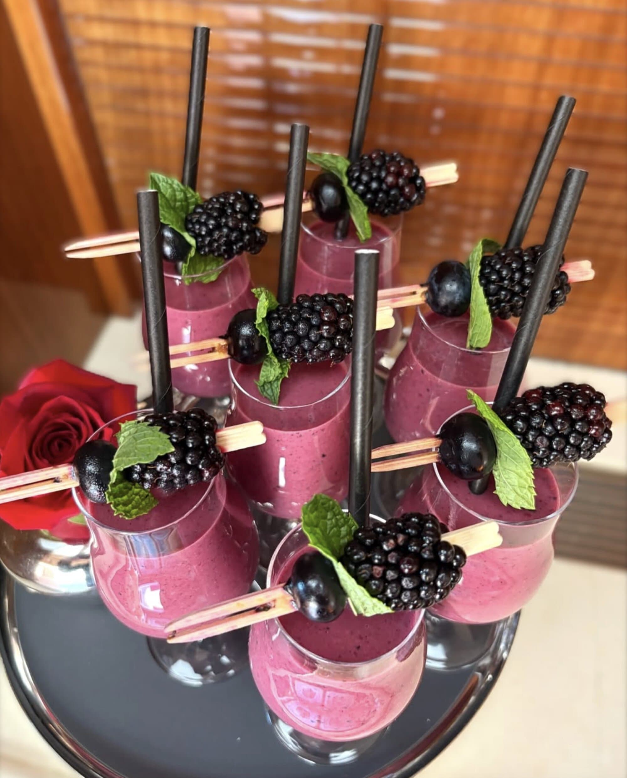 Blackberry smoothie shots garnished with mint and fresh berries